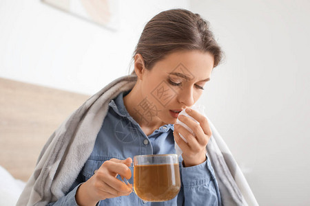 生病的女人在家喝热茶图片