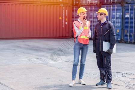 后勤工人男女工作团队用无线电控制将港口货物的集装箱载到卡车上图片