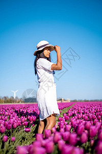 荷兰郁金香田里穿着裙子和夏帽的女人图片