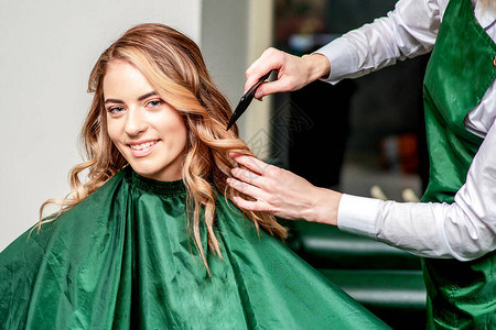 理发师给女孩梳头快乐的年轻女人和理发师在美发沙龙图片