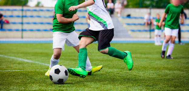 运行足球员青年足球队之间的体育比赛硬决斗中踢足球比赛的年轻男孩少年足球背景