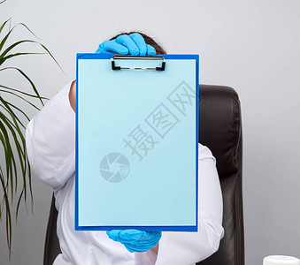 蓝色医用乳胶手套的医生手握着一个文件夹图片