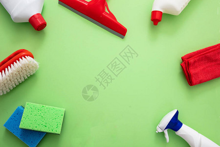 家庭清洁背景绿色背景上的清洁产品平铺化学洗涤剂瓶和设备顶视图片