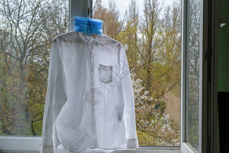 纯粹的白衬衫和蓝面罩衣服挂在开窗处的背景图片