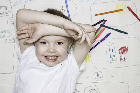 小男孩在大图画和标记的背景上微笑儿童休闲绘画图片