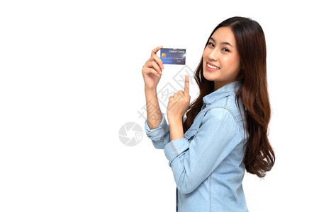 一位快乐的年轻女手持自动取款机借记卡或信用卡并用于在线购物图片