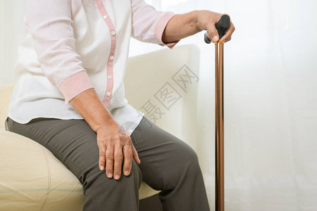 高龄妇女用棍棒的膝腿痛高年级概图片