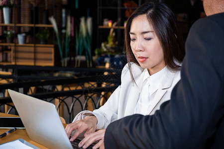 身着正装的亚洲商人和女商人正在用高科技笔记本电脑在当时的现代办公图片