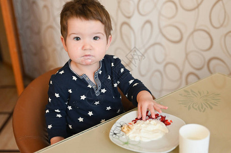 孩子坐在桌子上独自吃粥背景图片