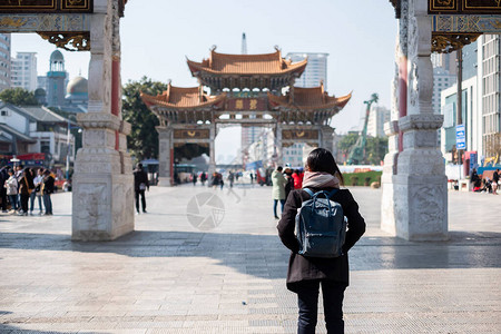 在金碧广场金马和玉鸡牌坊旅行的年轻女子旅行者图片