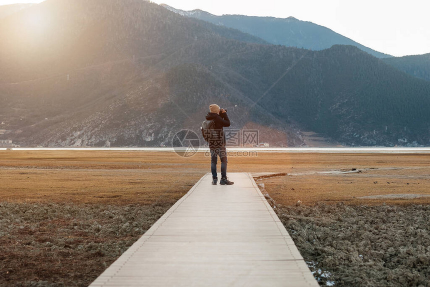 穿着毛衣和背包在纳帕湖旅行的时髦男子旅行者图片