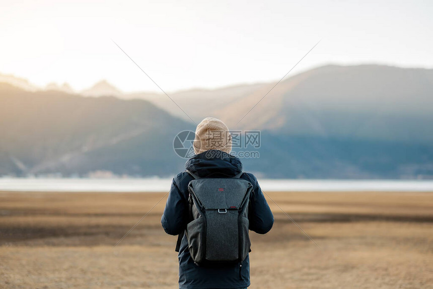 穿着毛衣和背包在纳帕湖旅行的时髦男旅行者图片