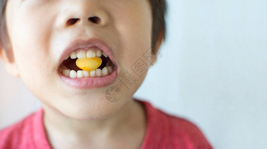 小男孩在嘴里咬黄糖上图片
