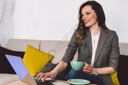 成功自信的中年女教师在上网课前喝杯咖啡图片