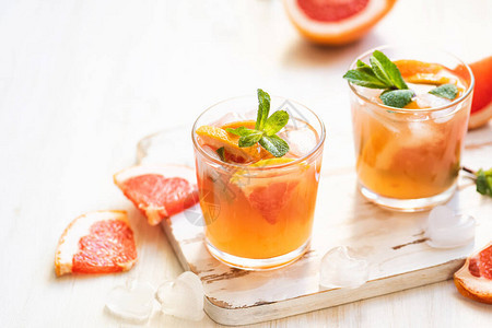含有薄荷和冰的葡萄果鸡尾酒寒冷的夏季柑橘仁淡木背景图片