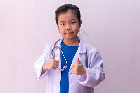 亚洲女孩手里拿着听诊器扮演医生图片
