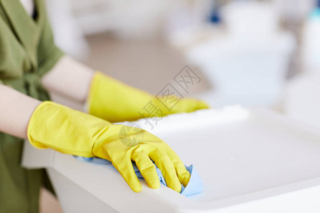 在家清洁塑料容器时戴着黄色橡胶手套的面目全非的女人的特图片