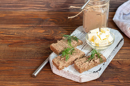 咖啡研磨器新鲜的自制鸡肝酱配胡萝卜洋葱和黄油饰以莳萝小枝涂在面包上在一个木制的背景背景