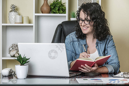 身着临时服装和眼镜的快乐成年妇女阅读笔记本电脑数据图片