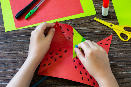 折纸指导步骤9纸风车有趣的玩具西瓜风车在木桌上旋转儿童艺术项目针线活背景图片