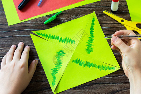 折纸指导步骤8纸风车有趣的玩具西瓜风车在木桌上旋转儿童艺术项目针线活背景图片