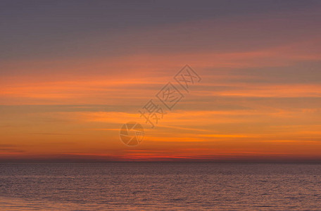 明亮的暮色日落天空在海面上日落后橙色调的美妙天空自然背景海洋和天空的紫色调背景图片