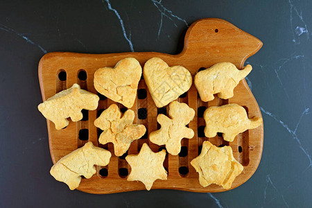 刚烤过的自制黄油饼干在木质面包板上被冷背景图片