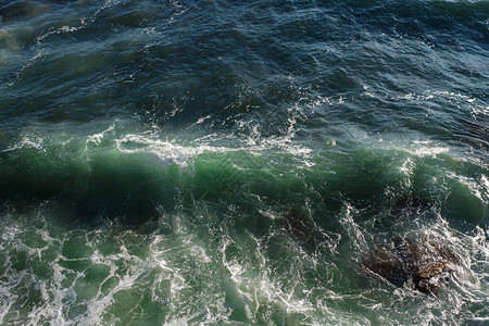 海浪背景打破海水岩石海岸波涛汹涌的大海绿松石水梯度泡沫在公海的大浪夏季风海背景图片