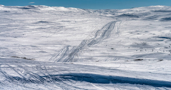 在瑞典挪威山区的雪地摩托小径上放大视图许多游客通过雪景开车上山图片