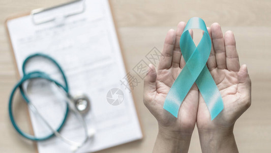 妇女手上的蓝绿色丝带意识对卵巢癌多囊卵巢综合征PCOS疾病创伤后应激障碍PTSD抽动秽语综合征强迫症图片