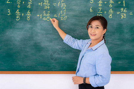 亚洲小学教师在黑板上解释数学图片