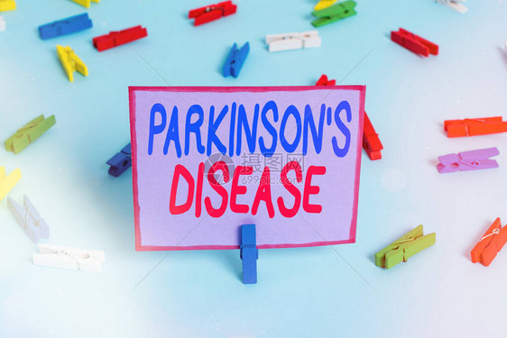 显示帕金森病的书写笔记晚年慢进行神经系统疾病的商业概念彩色衣夹纸空提醒蓝图片