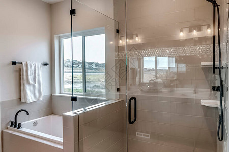 无框步入式淋浴间和瓷砖墙浴室内的置浴缸房间内还可以看到黑色的水龙头淋图片