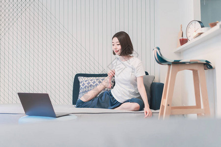 回家在客厅上在线瑜伽课的亚洲年轻女背景