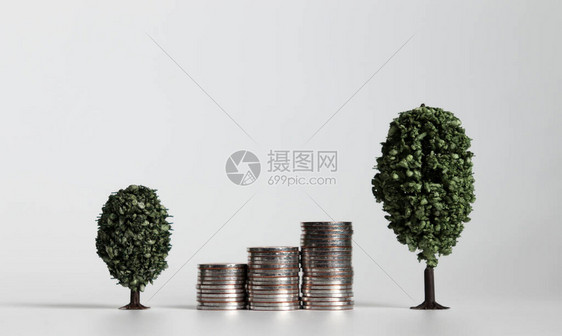 三堆硬币在两棵微型树之间图片