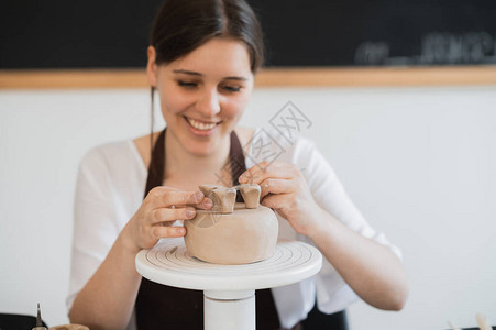 青年妇女将粘土产品部分附于未来的陶瓷产品Potter图片