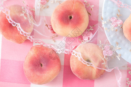 在桌布上撒开的浅粉红桃子甜背景图片