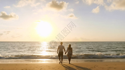 快乐的情侣在海滩上手牵到海洋冲浪在热带度假胜背景图片