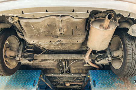 在旧车的紧身后轮轴悬吊和排气室消音器灭菌器下背景图片