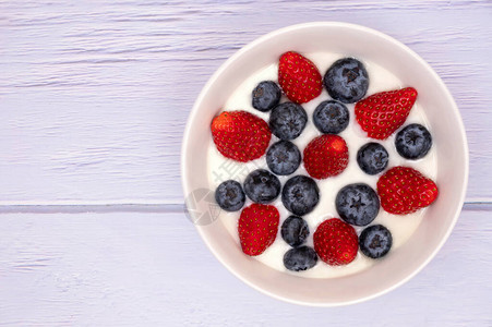 一碗天然酸奶配上新鲜的蓝莓和草莓图片