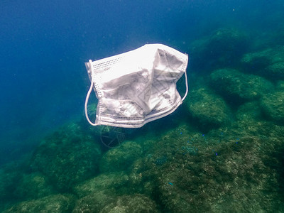 人们在海水中扔出医用口罩用过的外科口罩漂浮在海底无用的考拉卫生面具图片