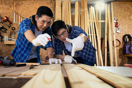 木匠测量和砍木头做家具两家木匠在一图片