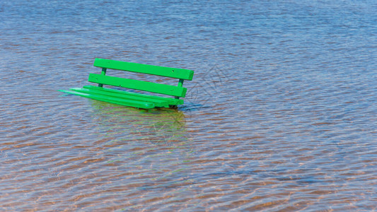 在被水淹没的沙滩上的木凳海上涨潮或涨水图片