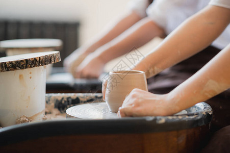 用电线切割产品工匠手制作陶碗在陶轮上工作的女人家族企业图片