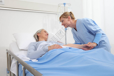 护士安慰躺在病房床上的老妇人图片