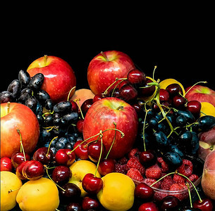 黑色背景上的水果桃子苹果杏子深蓝色葡萄红樱桃图片