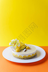 腰果蛋糕与芒果和椰子在黄橙色背景图片