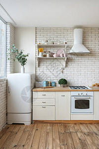 冰箱燃气灶具炊具内置烤箱设备架子上的厨具用品和厨房里的绿色植物的垂直视图背景图片