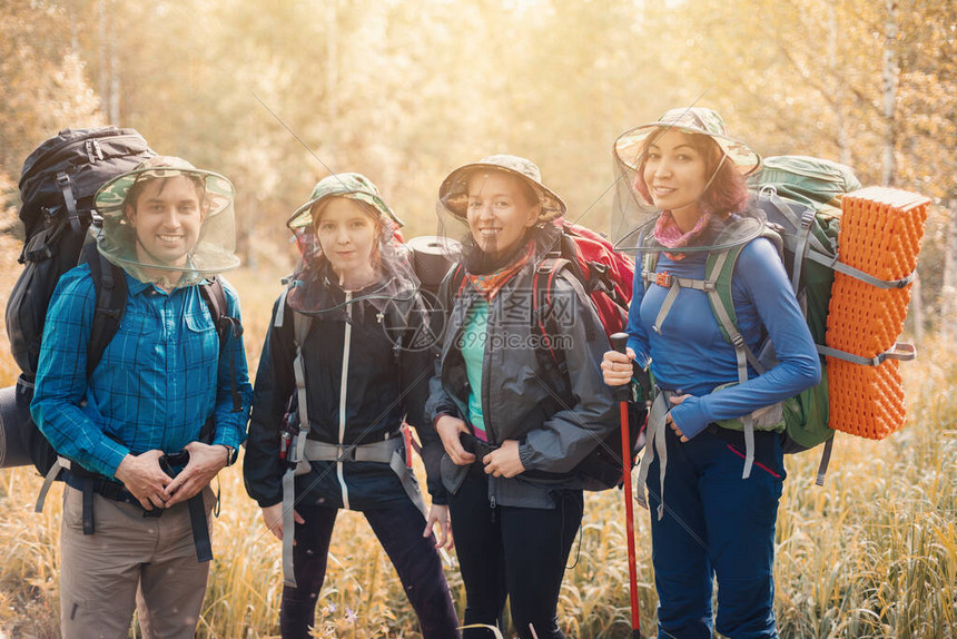 一群快乐的徒步旅行者在自然公园里戴着一顶带防蚊网的帽子防止吸血昆虫携带图片