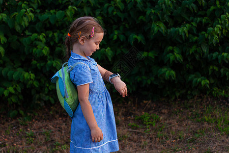 孩子在公园户外使用智能手表孩子在智能手机上谈视频通话女学生在浏览互联网的手表上使用触摸屏带GPS追踪背景图片